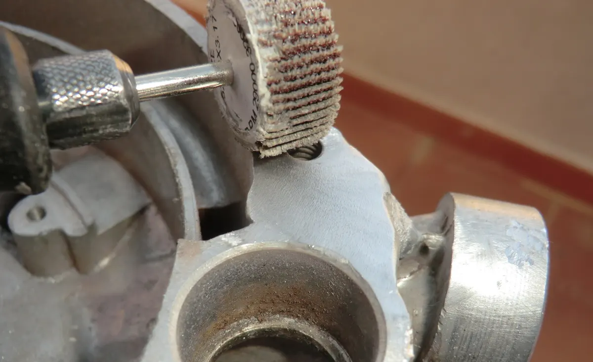 Vista del uso de una lija de milohojas para suavizar la superficie fresada por exceso de soldadura por el refuerzo en el cárter de Vespino.