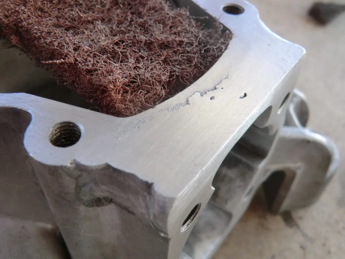 Rallado de superficie planificada de carter con estropajo grueso para facilitar la aplicación de pasta de juntas posteriormente