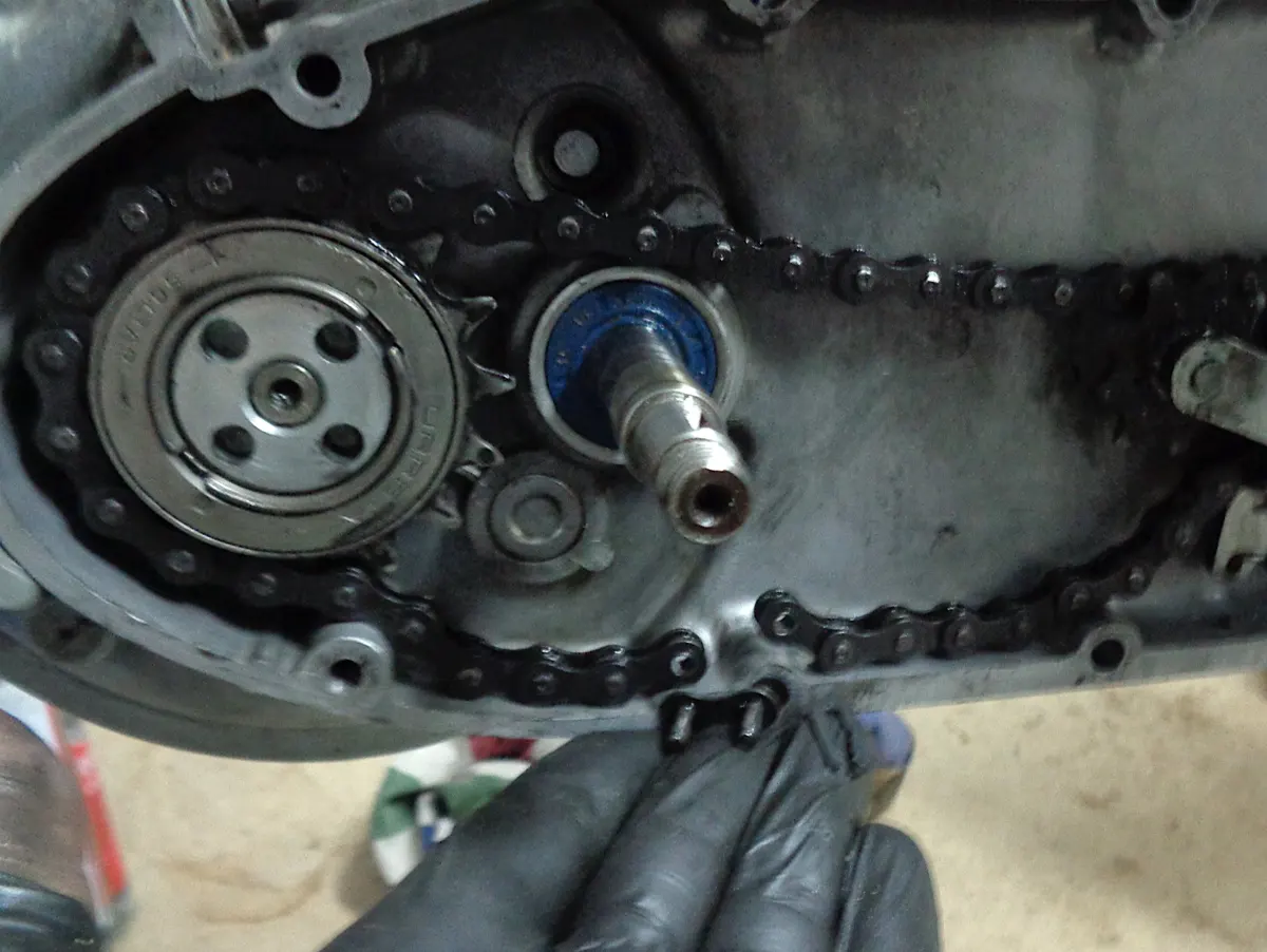 detalle del proceso de montaje de la cadena de un vespino con el eslabón que la cierra