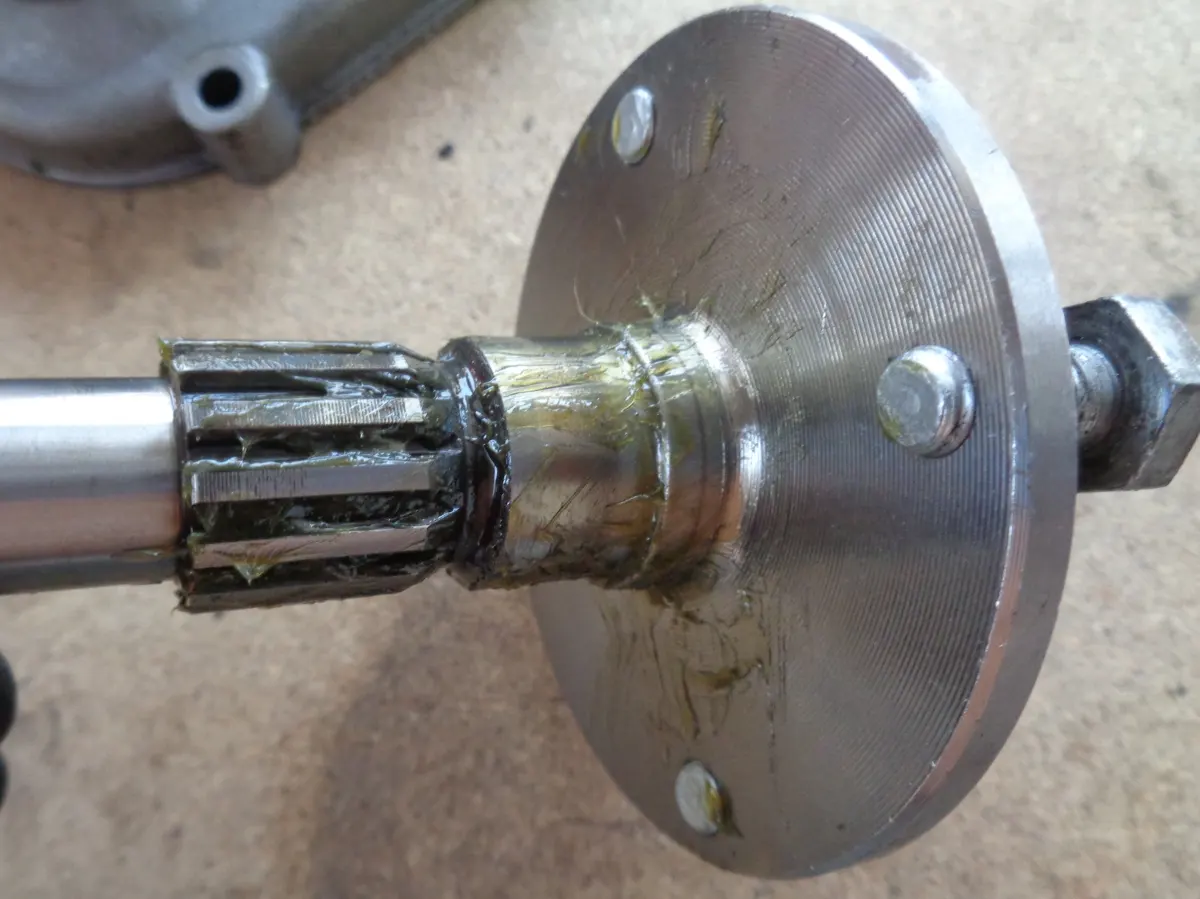 Eje portarueda de vespino, fuera de la reductora, y engrasado de su almenado para su montaje