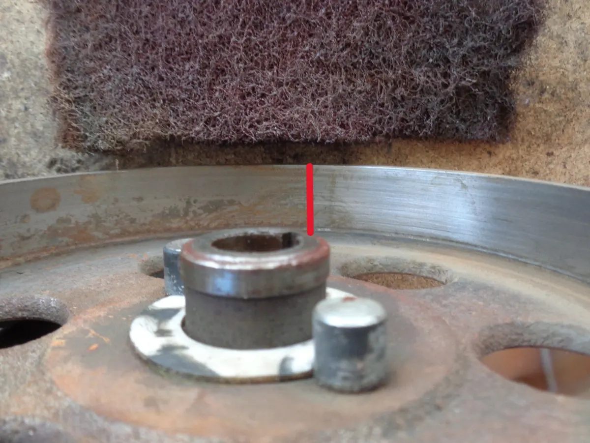 Campana de embrague de Vespino en proceso de limpieza con estropajo, la mitad limpia la otra mitad con óxido con una linea divisoria entre ambas para apreciar la diferencia