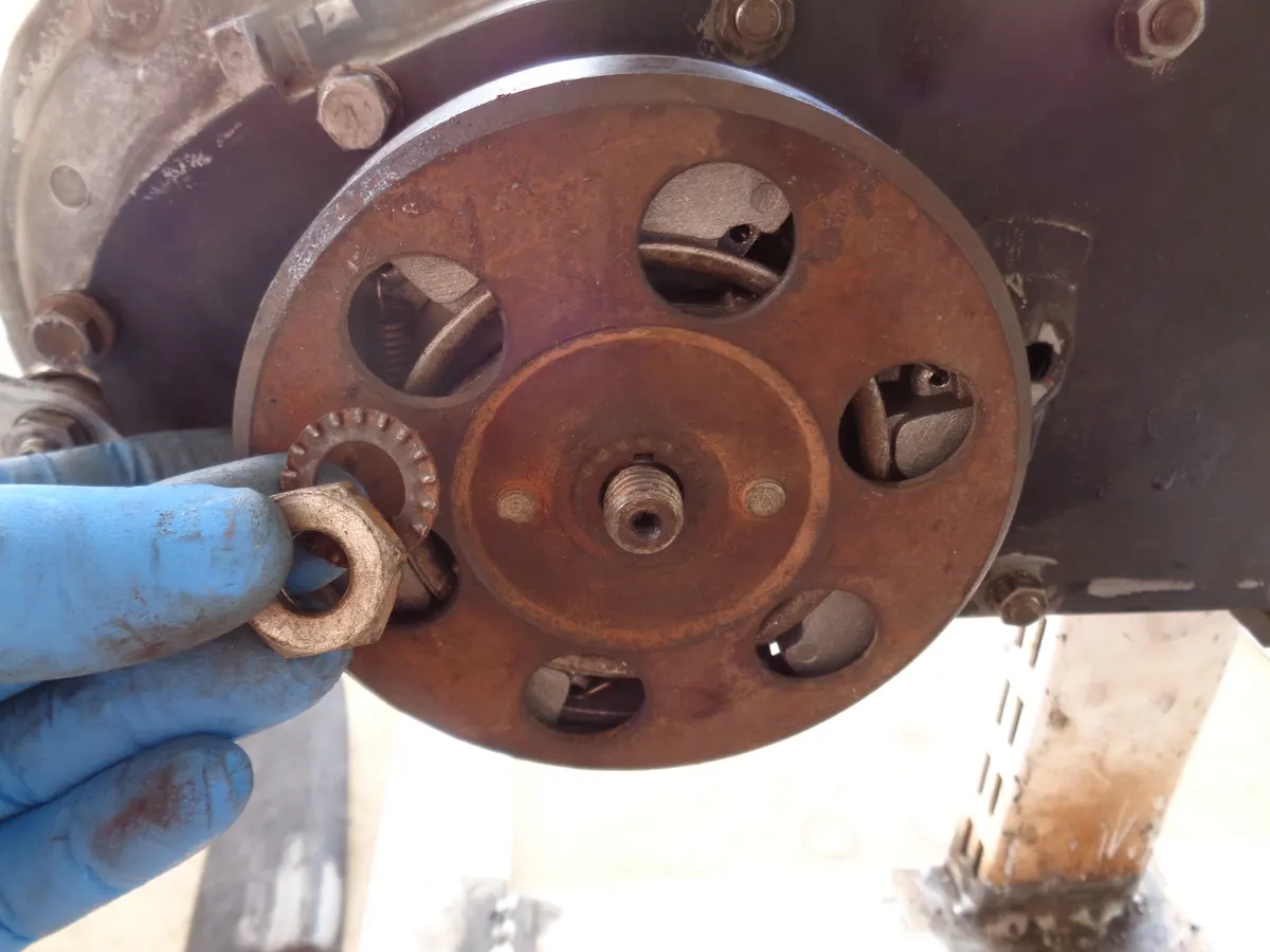 Tuerca y arandela junto al embrague del vespino que debe montarse en el eje portapolea