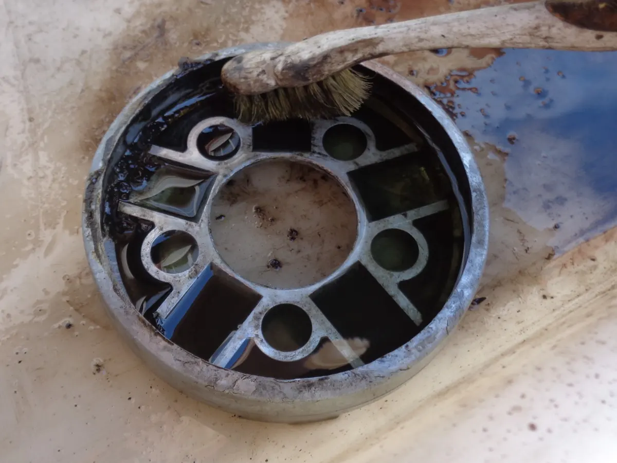 Limpieza de la guía de rodillos del variador de vespino con un cepillo de dientes y gasolina