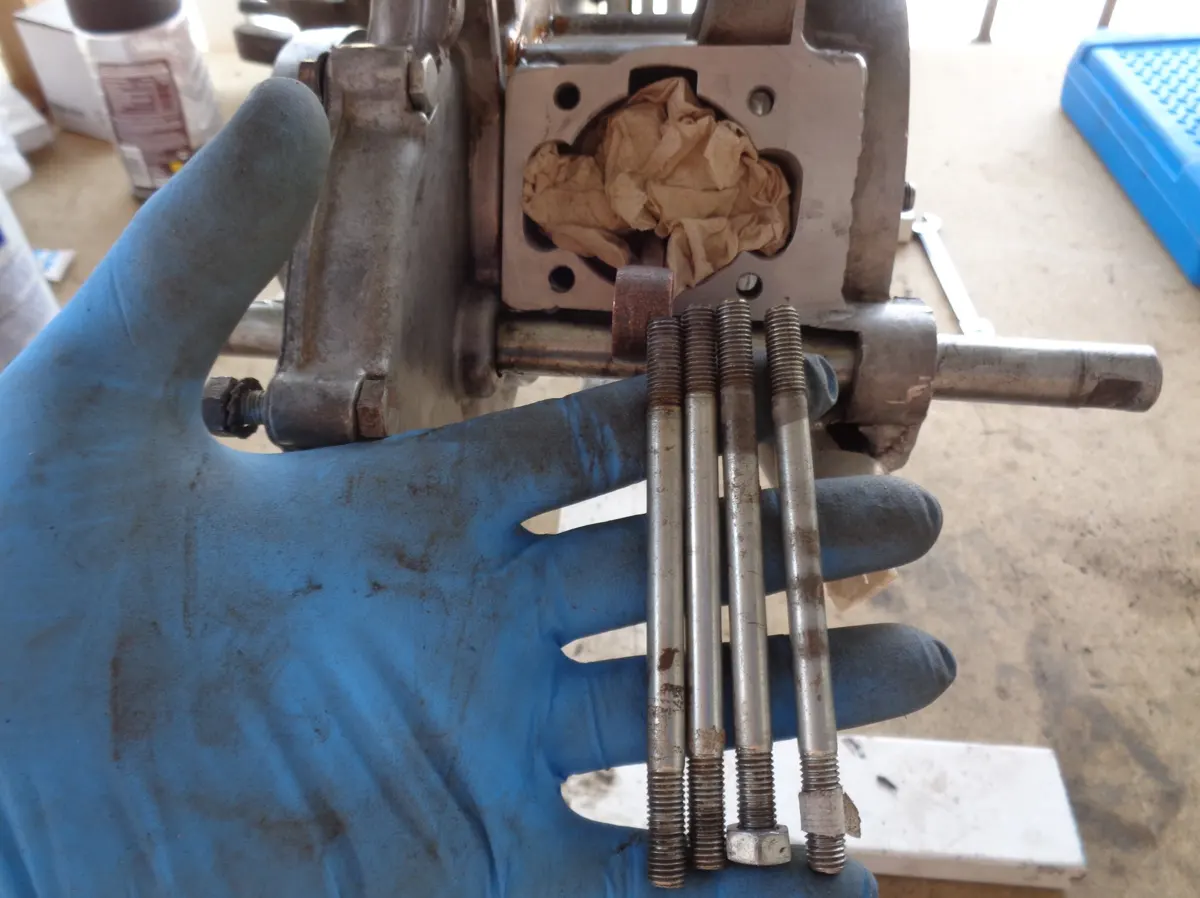 motor de vespino sin espárragos de cilindro montados, y frente a este los 4 espárragos a montar