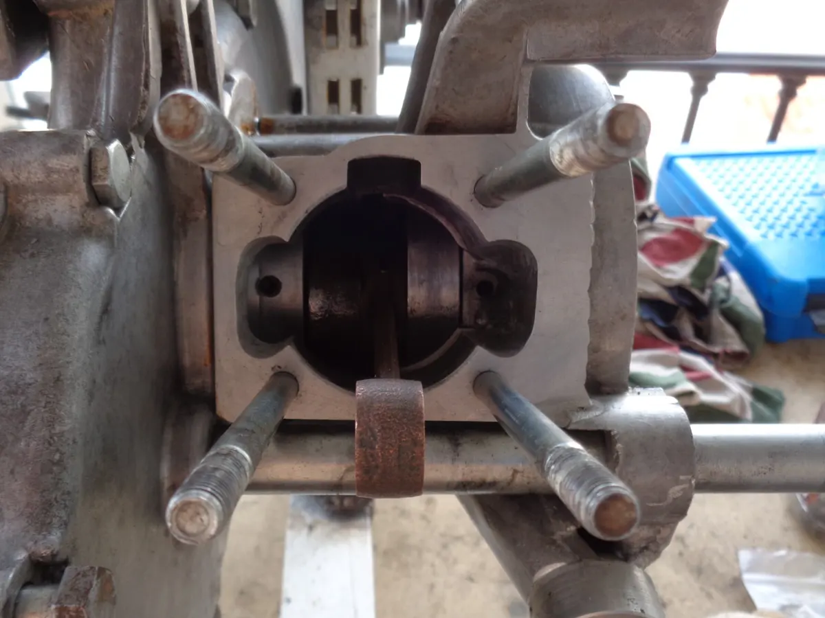 vista frontal de los cuatro espárragos del cilindro de un vespino montados en el motor sin cilindro y con el cigueñal a la vista