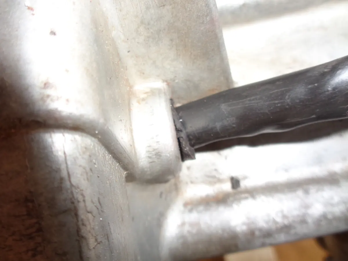 Detalle del la salida de los cables del estator del encendido de un vespino a través del pasacables situado en el carter