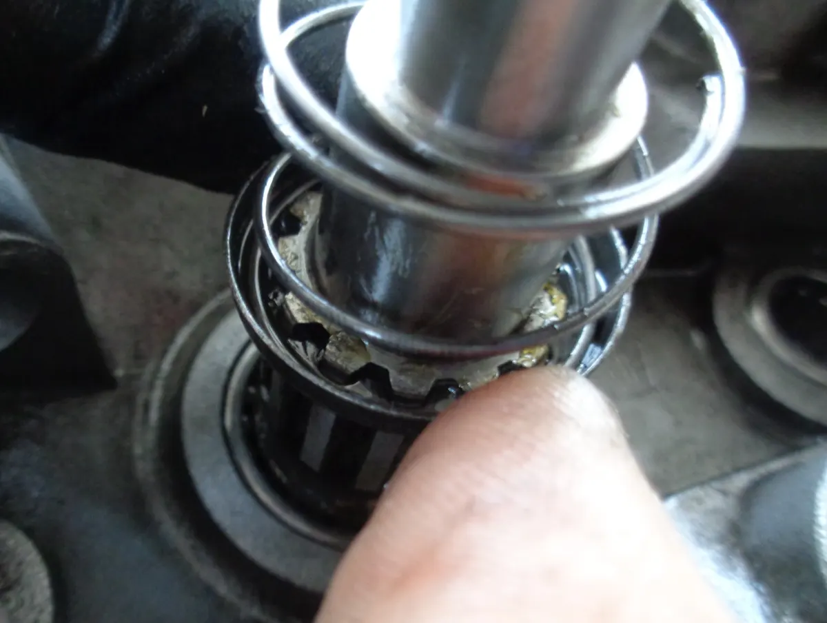 Introducción de la cazoleta almenada y su muelle en el eje portarueda en el proceso de montaje de una reductora de vespino