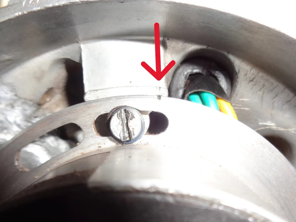 detalle de la marca de avance de encendido del vespino con una flecha indicando la coincidencia de marcas entre carter y estator