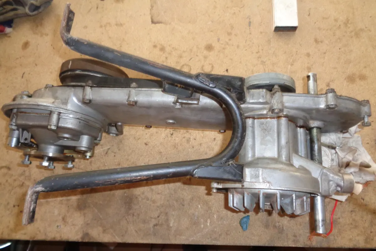 motor de vespino boca abajo en una mesa en proceso de restauración con el caballete posicionado sin su eje ni muelle