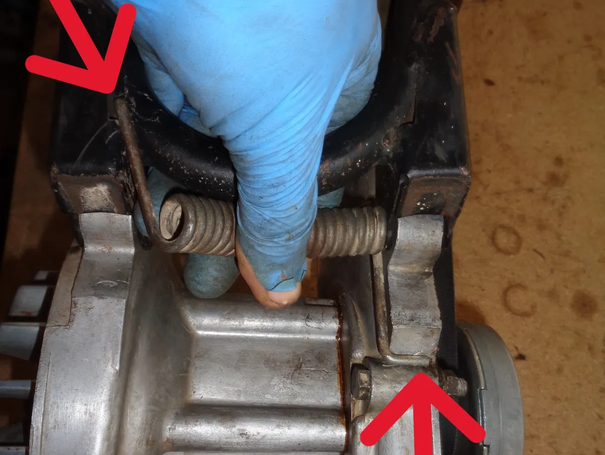 Ilustración con flechas del posicionamiento del muelle del caballete central de un vespino antes de montar el eje