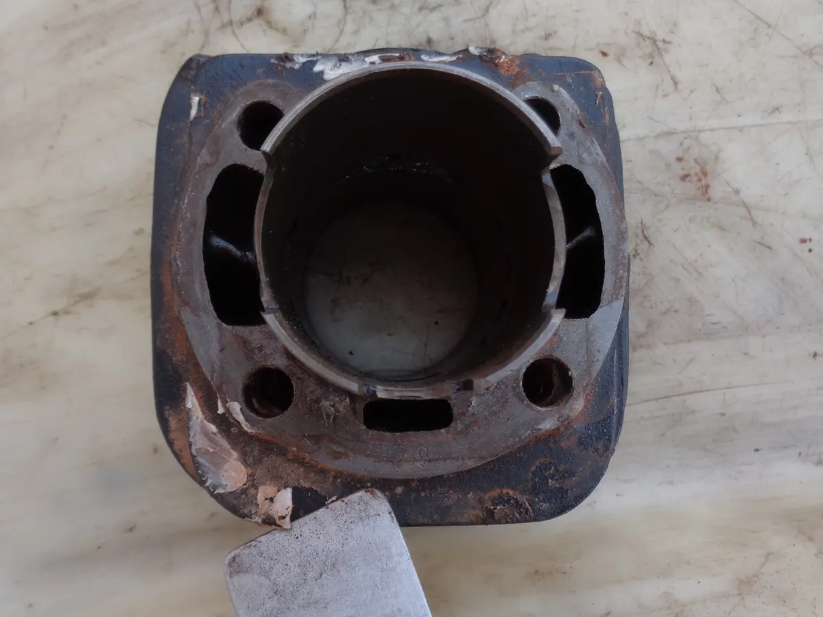 Base de cilindro de vespino al que con una espátula están eliminando los restos de silicota y suciedad