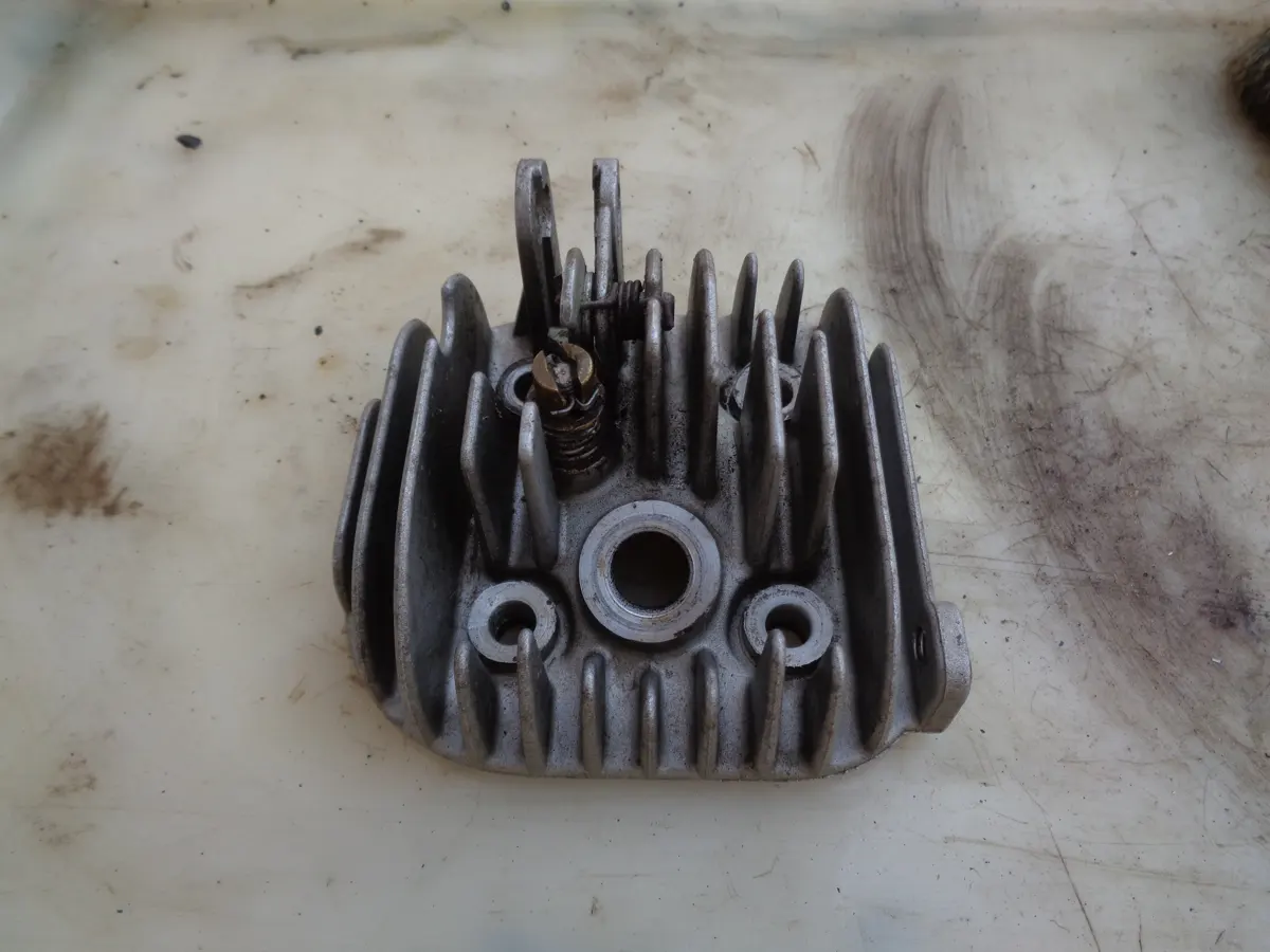 Vista superior de una culata de vespino desmontada sobre pa mesa 