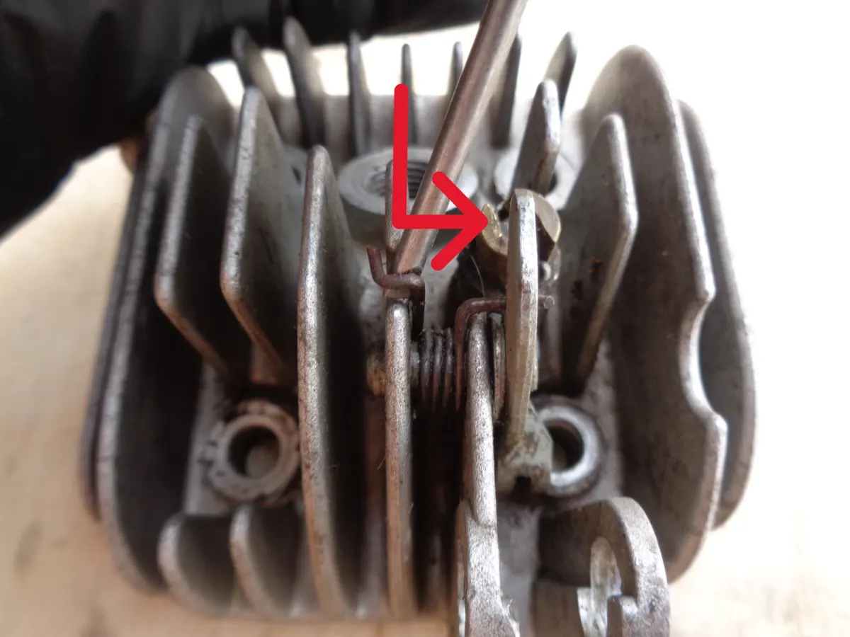 Ilustración con flechas de como desmonta la palanca del descompresor de la culata de un vespino 