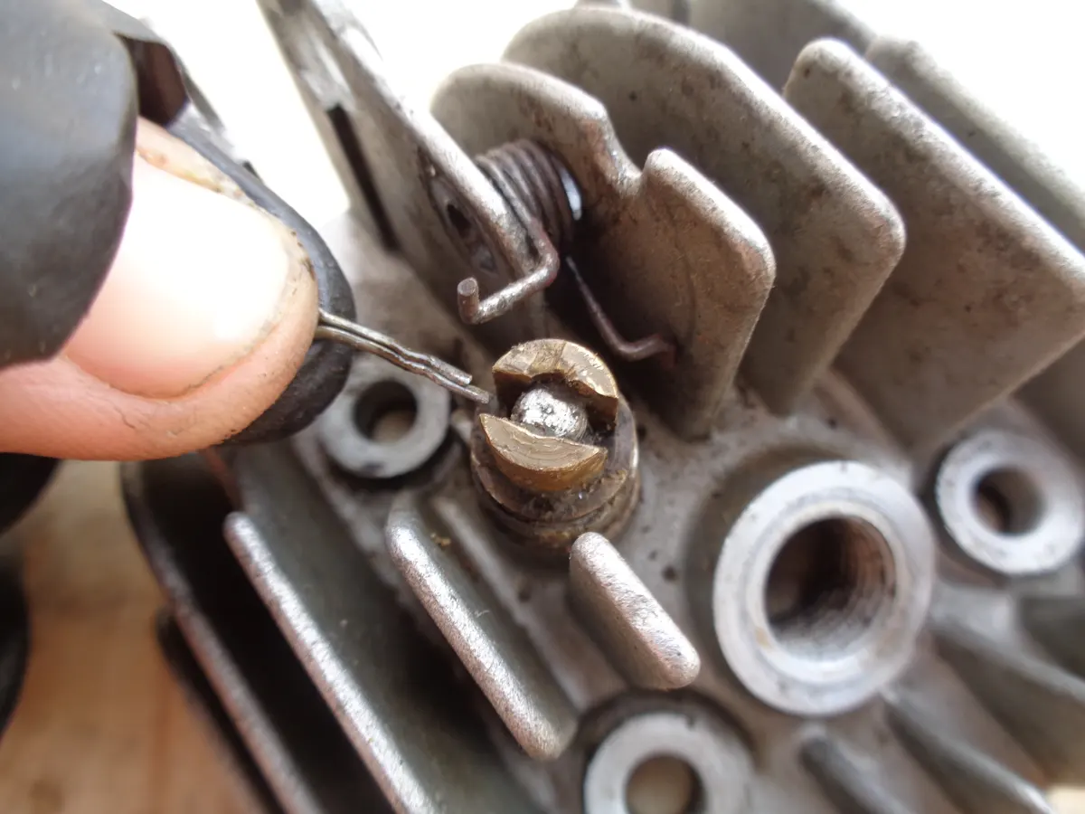 pasador de la válvula del descompresor de una culata de vespino retirada de su alojamiento junto al descompresor