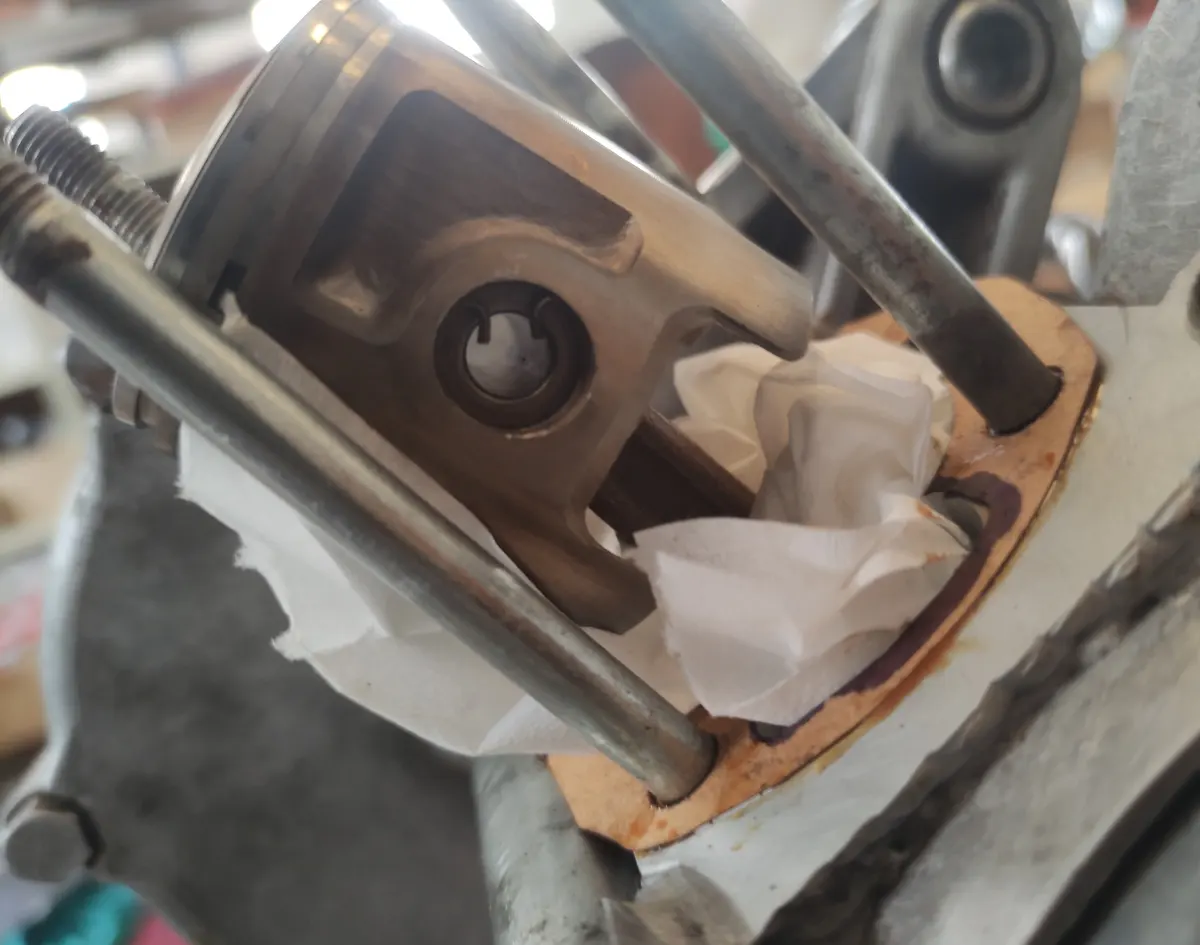 detalle lateral del pistón de un vespino montado en su biela con los circlips bloqueando el bulón