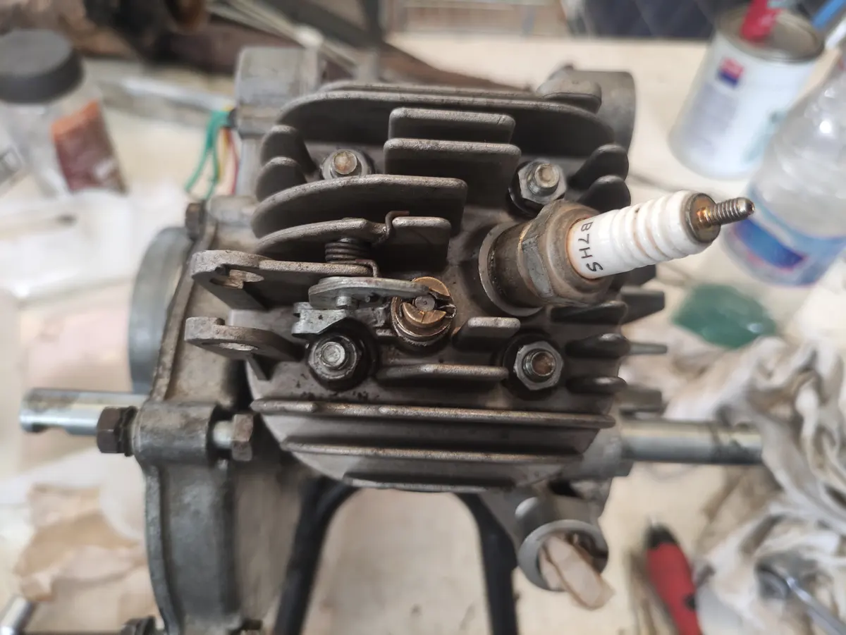 detalle de un motor de vespino visto desde la culata con su bujía