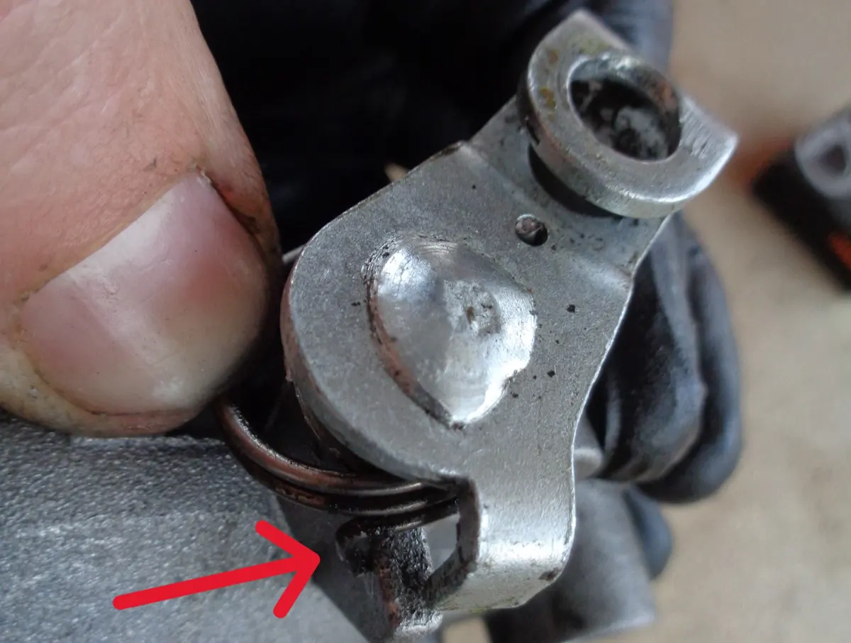 Detalle del posicionamiento de la punta del muelle de retorno de la palanca actuadora del eje del sistema bici-moto de vespino contra el carter de la reductora