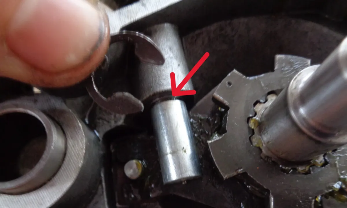 Detalle del proceso de colocación del circlip de la palanca del eje del sistema bici-moto de vespino en su alojamiento en la garganta del eje.