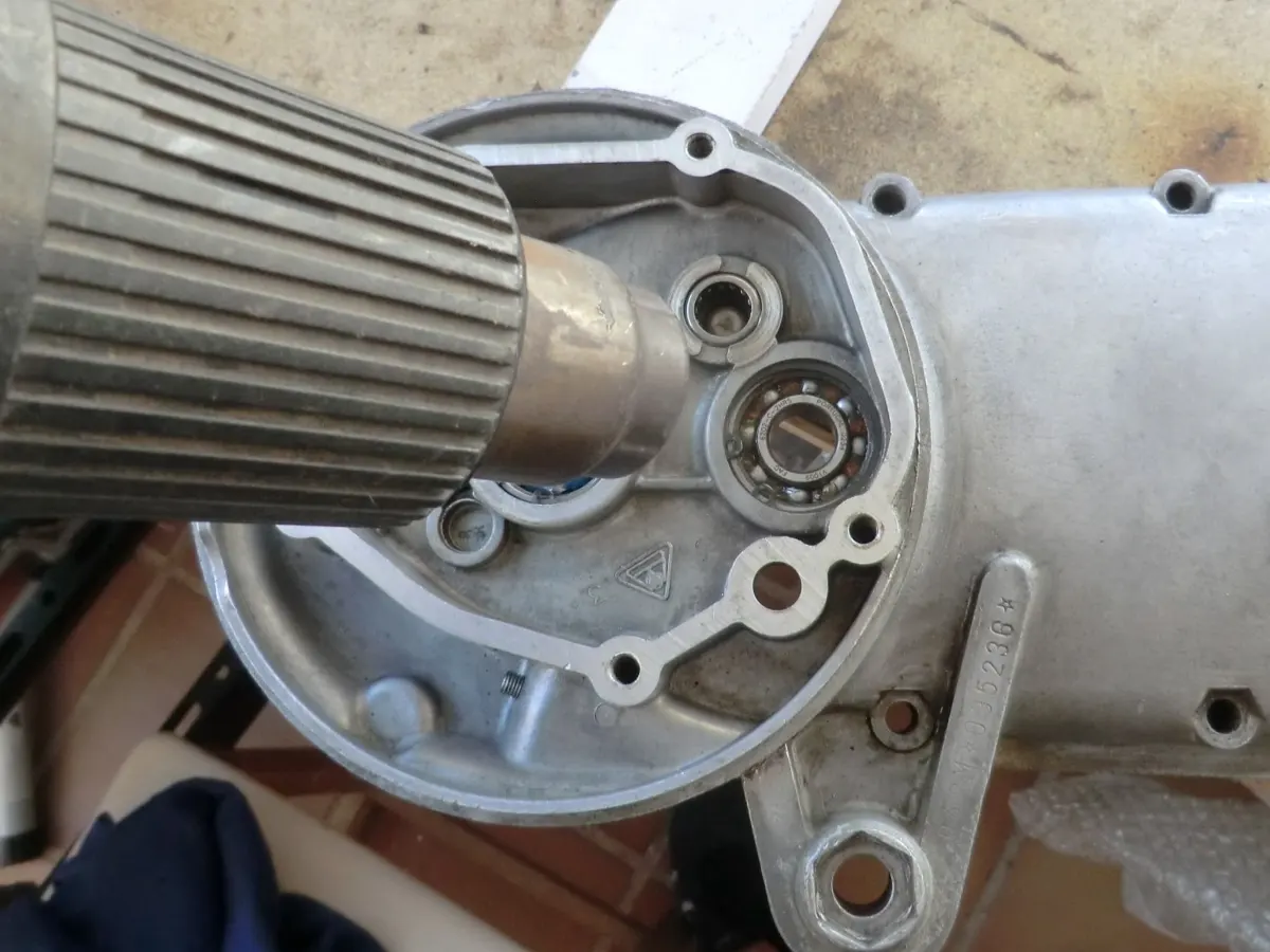 Detalle en del calentamiento mediante una pistola de calor de la pista interior del rodamiento del eje portapolea de la reductora de un vespino previo a montar el eje