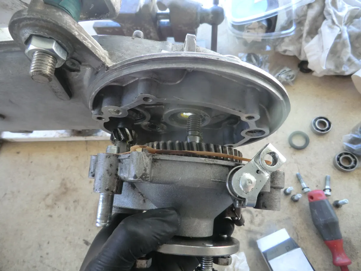 Momento en el que se está cerrando el carter de la reductora de un Vespino en el que se aprecian los engranajes y ejes encarandose en sus alojamientos