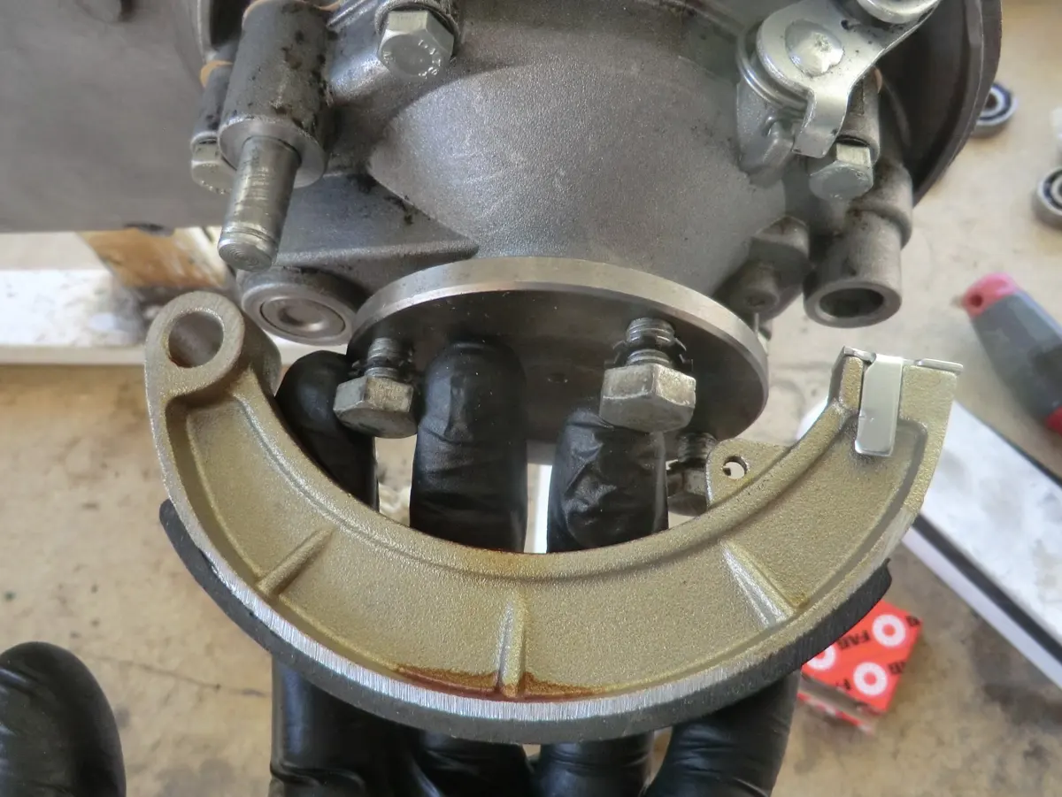 Zapata de freno trasero de vespino Newfren, junto al motor de un Vespino para proceder a su montaje en el motor 