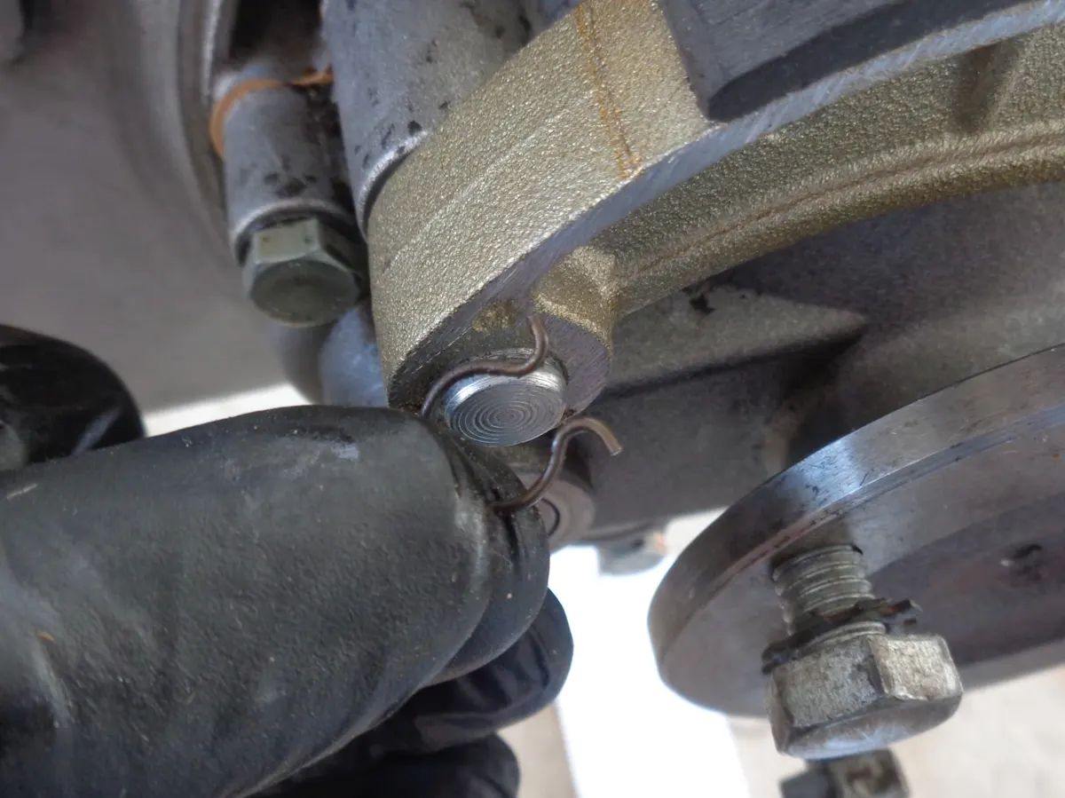 Detalle del muelle que bloquea la zapata de freno trasero de vespino para que no se mueva del eje sobre el que pivota