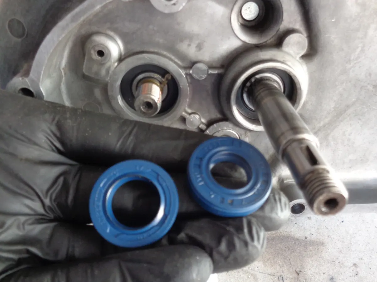 Mano osteniendo dor retenes que se van a montar en la reductora de un motor de vespino 