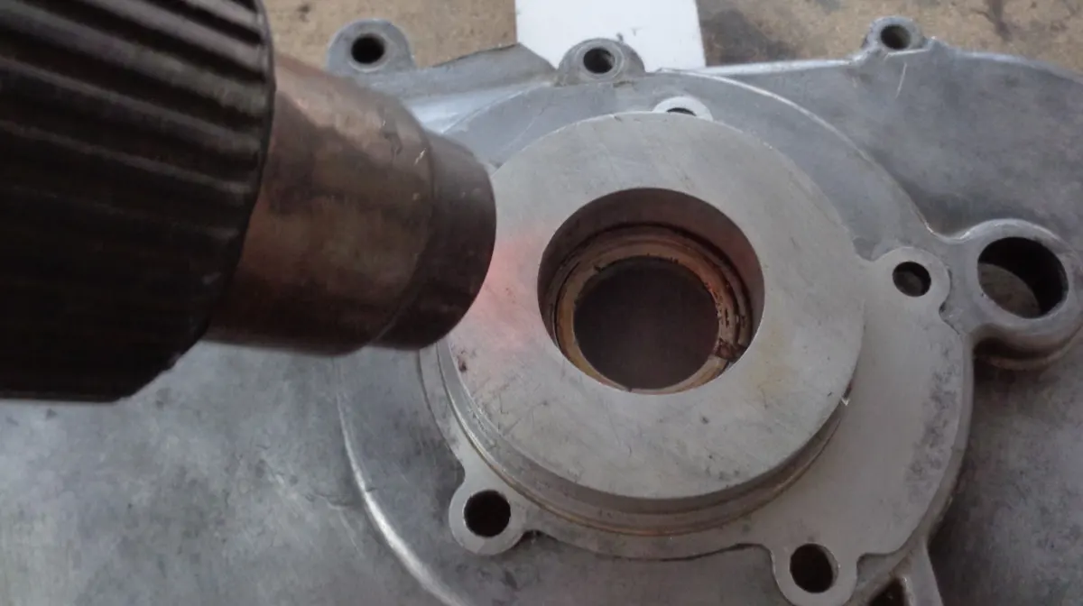 Carter largo de Vespino al que una pistola de calor está calentando para dilatar el alojamiento del rodamiento del cigüeñal para montar su rodamiento