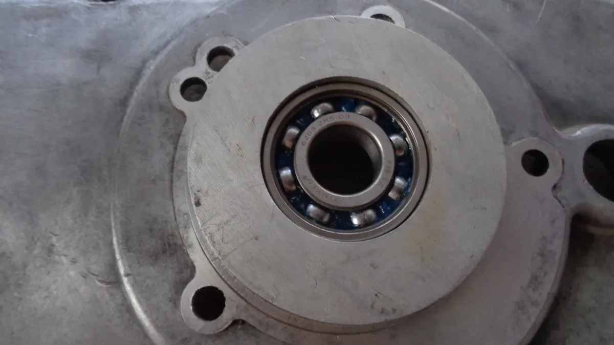 Rodamiento de cigüeñal de vespino montado sobre su alojamiento en el carter largo en el proceso de restauración de un motor de vespino