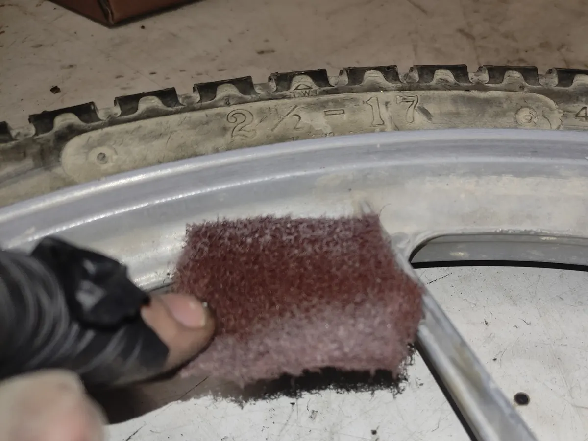 detalle del perfil de la llanta de un vespino limpio tras haber sido frotada con estropajo para liminar la mugre