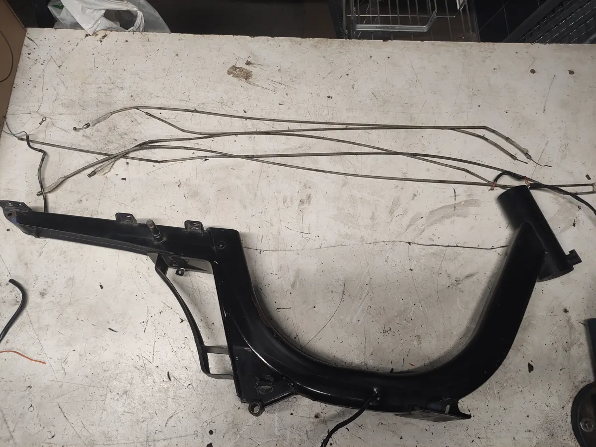 Chasis de Vespino totalmente desmontado sobre una mesa con los cables mecánicos junto a él una vez desmontados