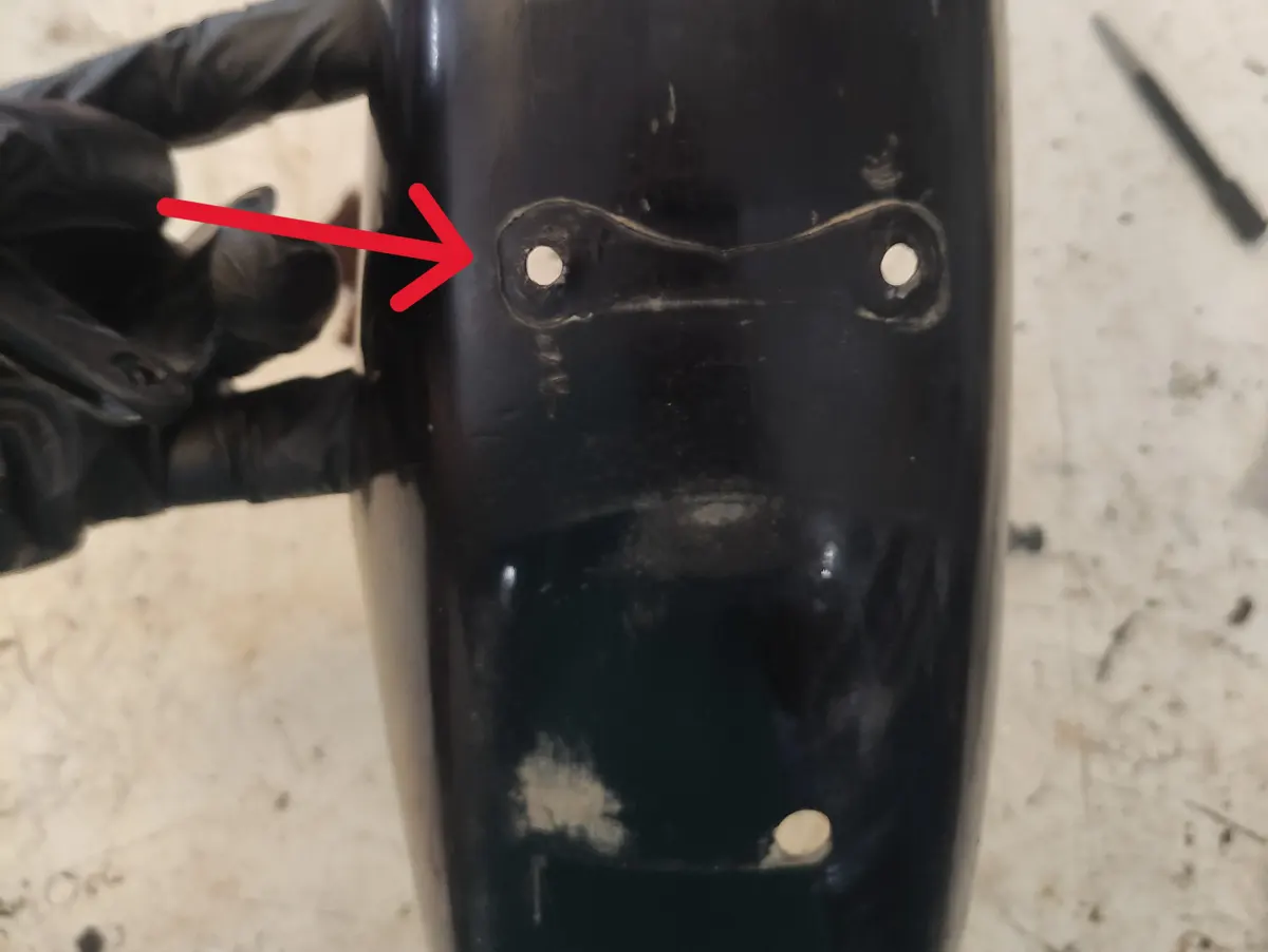 Detalle del punto en el amortiguador trasero en el que ha de anclarse el soporte del guardabarros