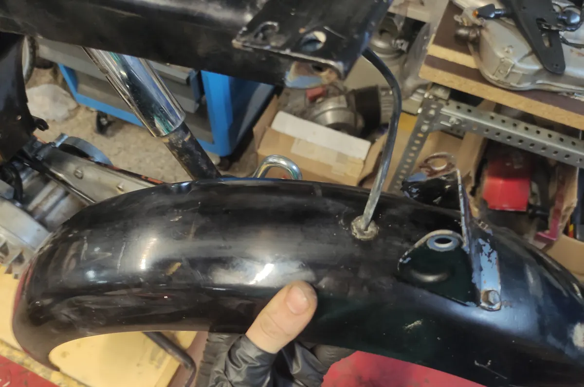 Paso de los cables del piloto trasero a través del guardabarros en su proceso de montaje