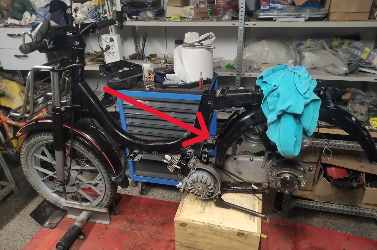 Vespino en proceso de restauración con una flecha indicando a los tornillos delanteros del guardabarros de un vespino SC