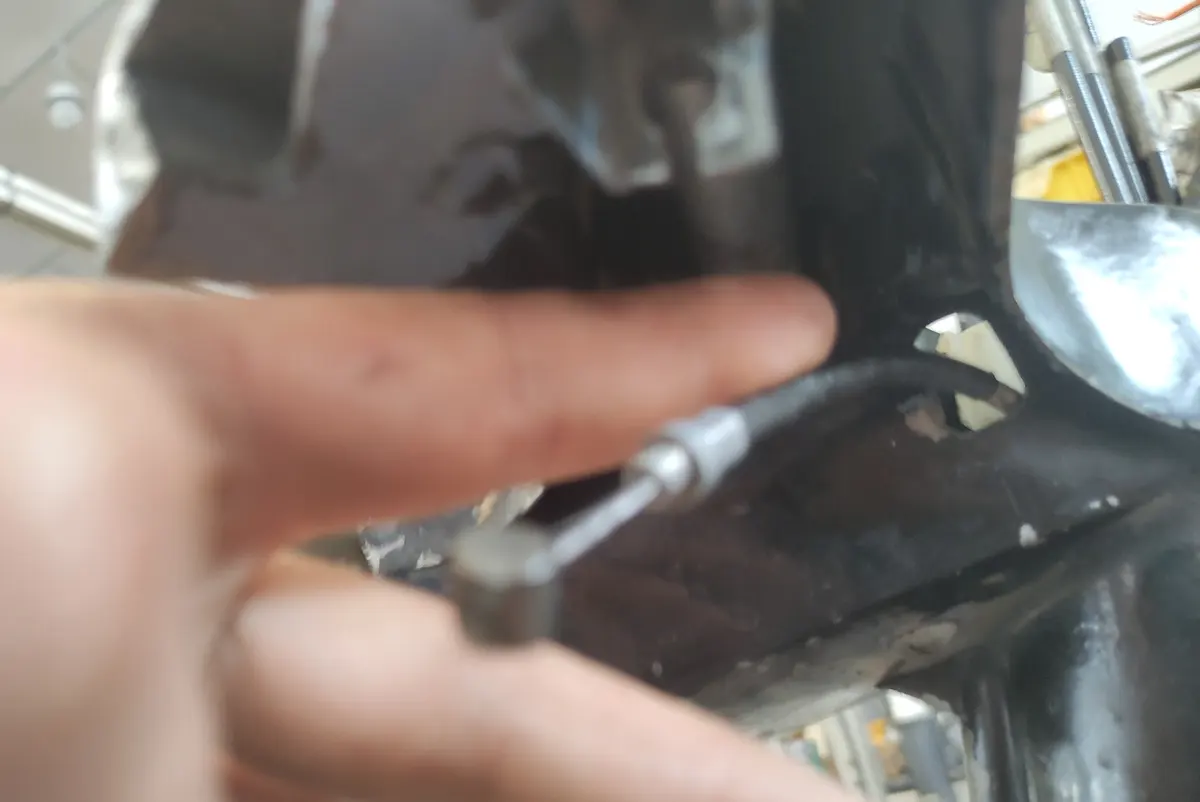 Detalle del cable de freno trasero de vespino atravesando el cabezón