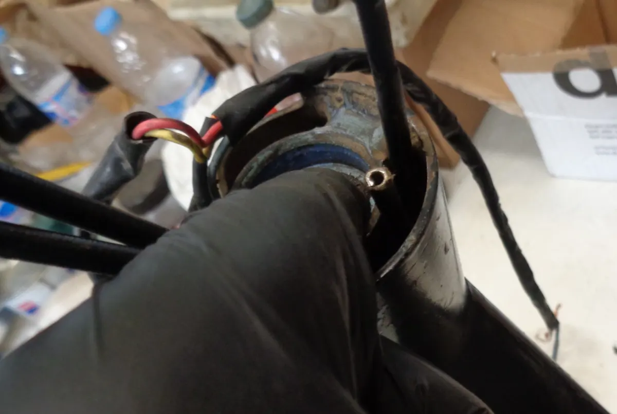 Cables de descompresor de Vespino saliendo por la tija del chasis extrayendolo con ayuda de un dedo através de la tija