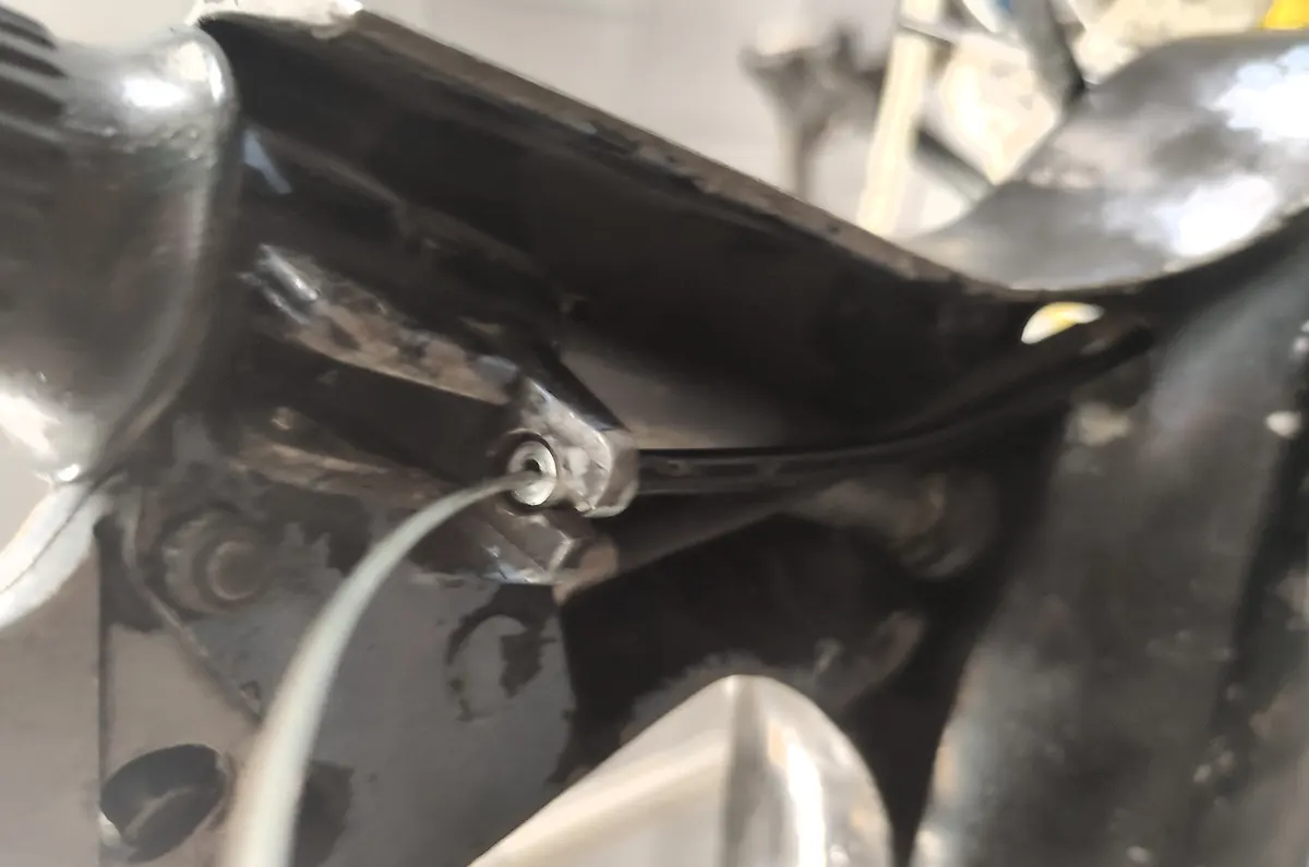 Detalle del punto de anclaje de cable del descompresor en el manillar del vespino