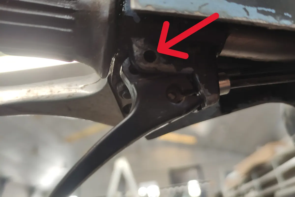 Detalle del gatillo del descompresor del vespino indicando con una flecha el lugar en el que se ancla el mismo al manillar