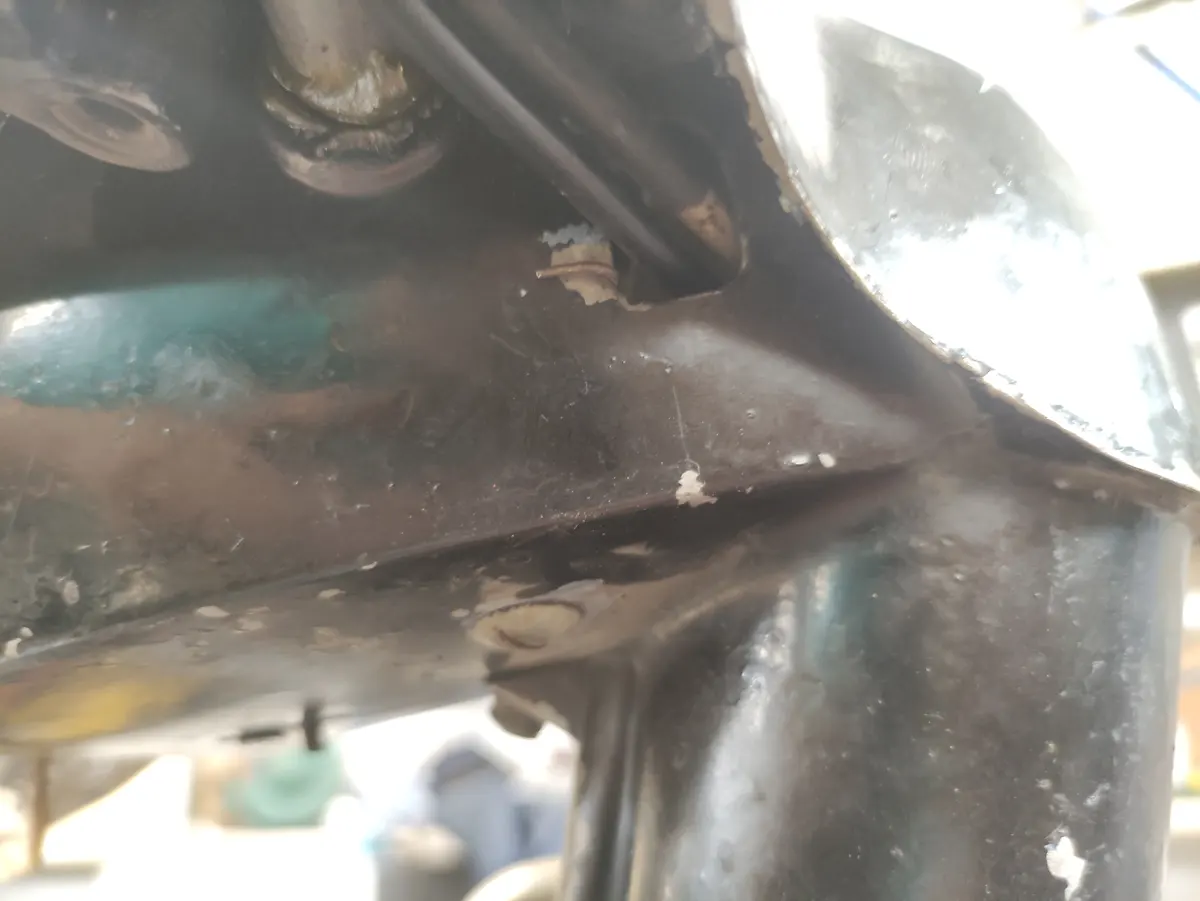 Detalle del proceso de montaje del faro de un vespino en el manillar, mostrando el anclaje final del muelle