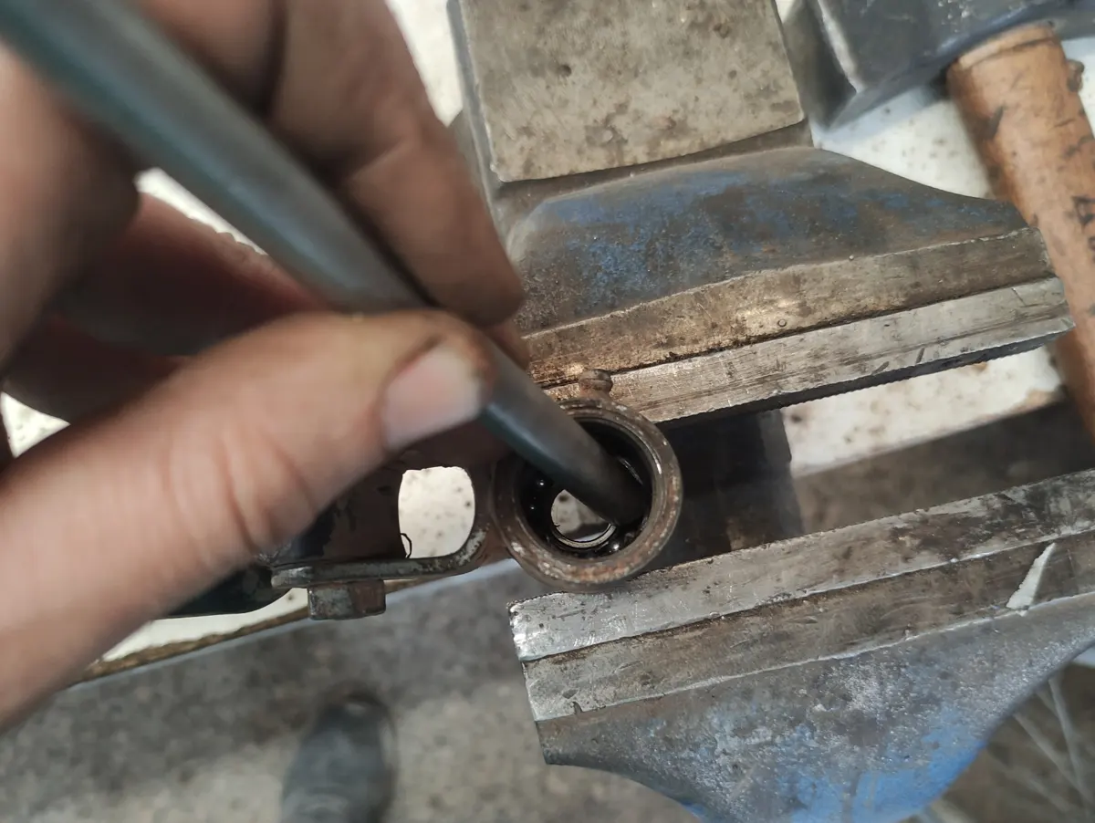 Rodamiento del amortiguador extra de vespino dañado siendo extraido con un puntero