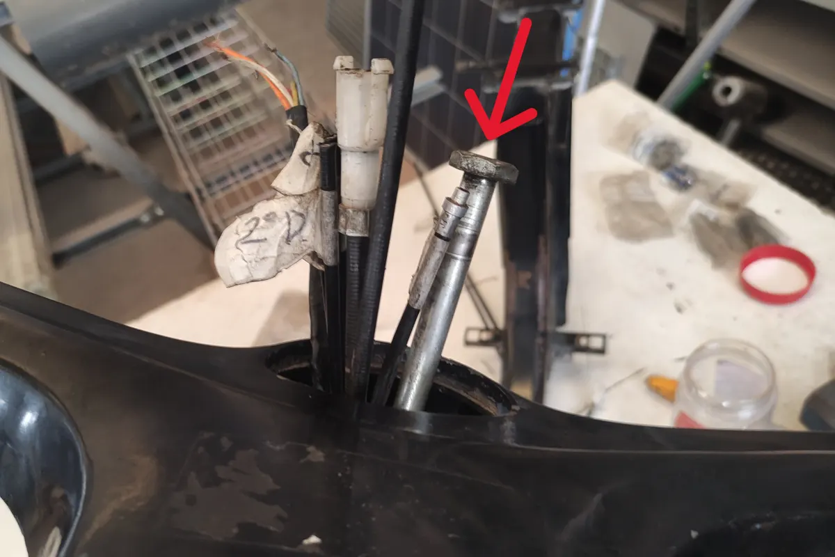 Detalle de la introducción del tornillo de dirección siendo introducido por la parte superior del manillar