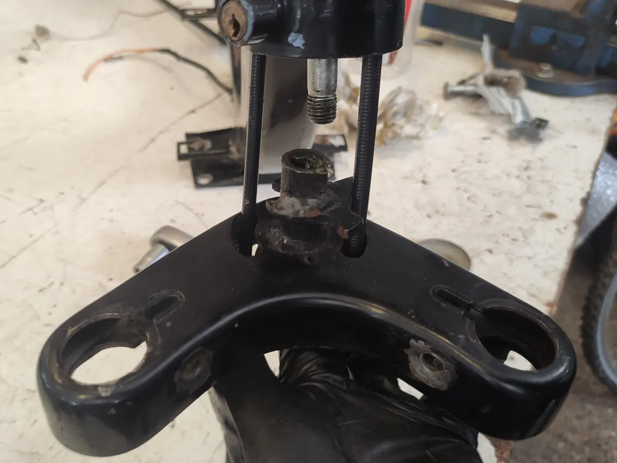 Detalle del momento en que se monta la tija inferior de la dirección de Vespino siendo esta atravesada por los cables de freno y ckm