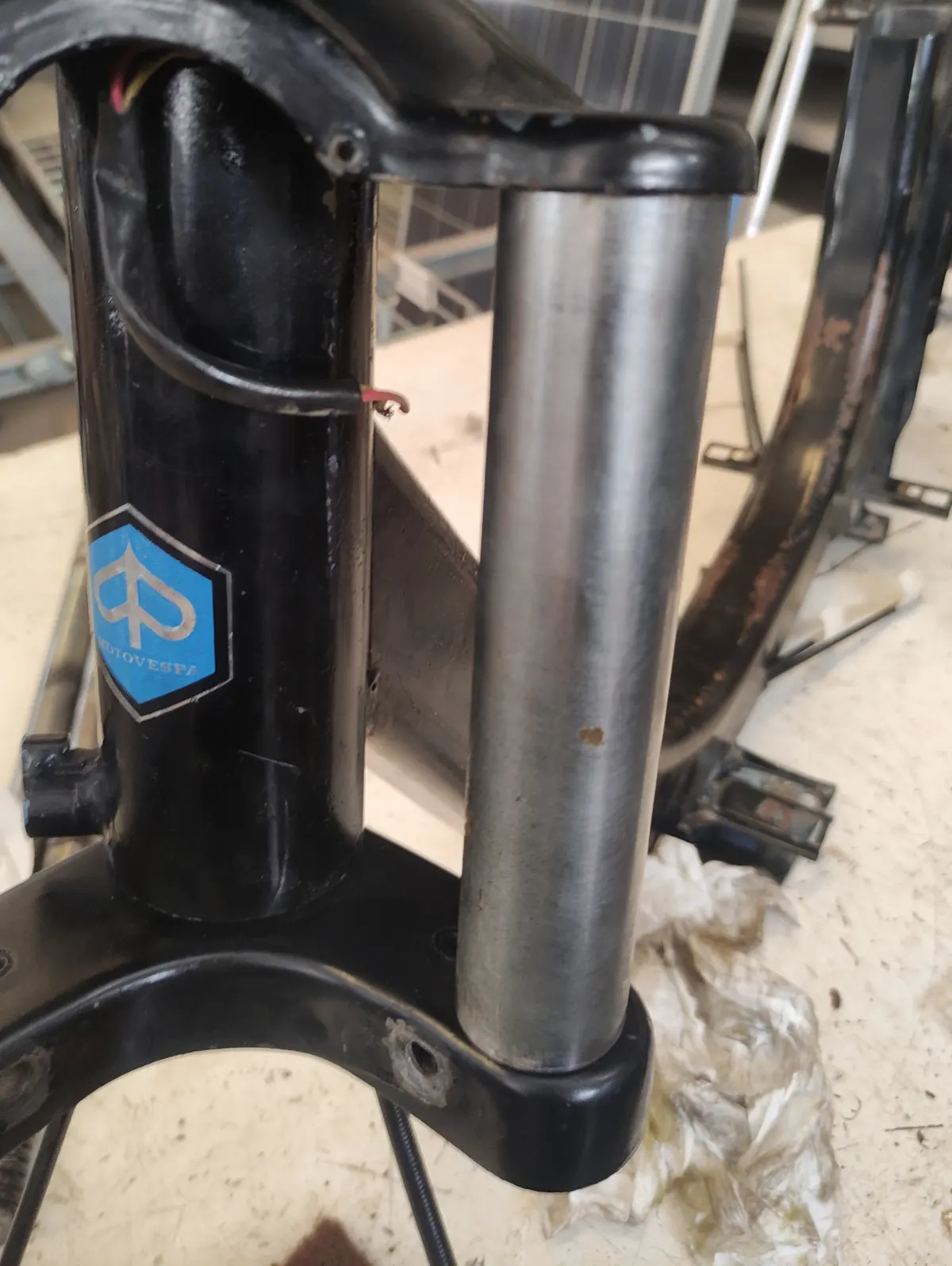 Detalle del montaje del embellecedor superior de la suspensión de un vespino en su posición entre las tijas