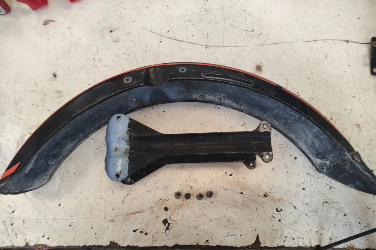 Guardabarros delantero de Vespino junto con el puente de la suspensión delantera sobre una mesa sin montar