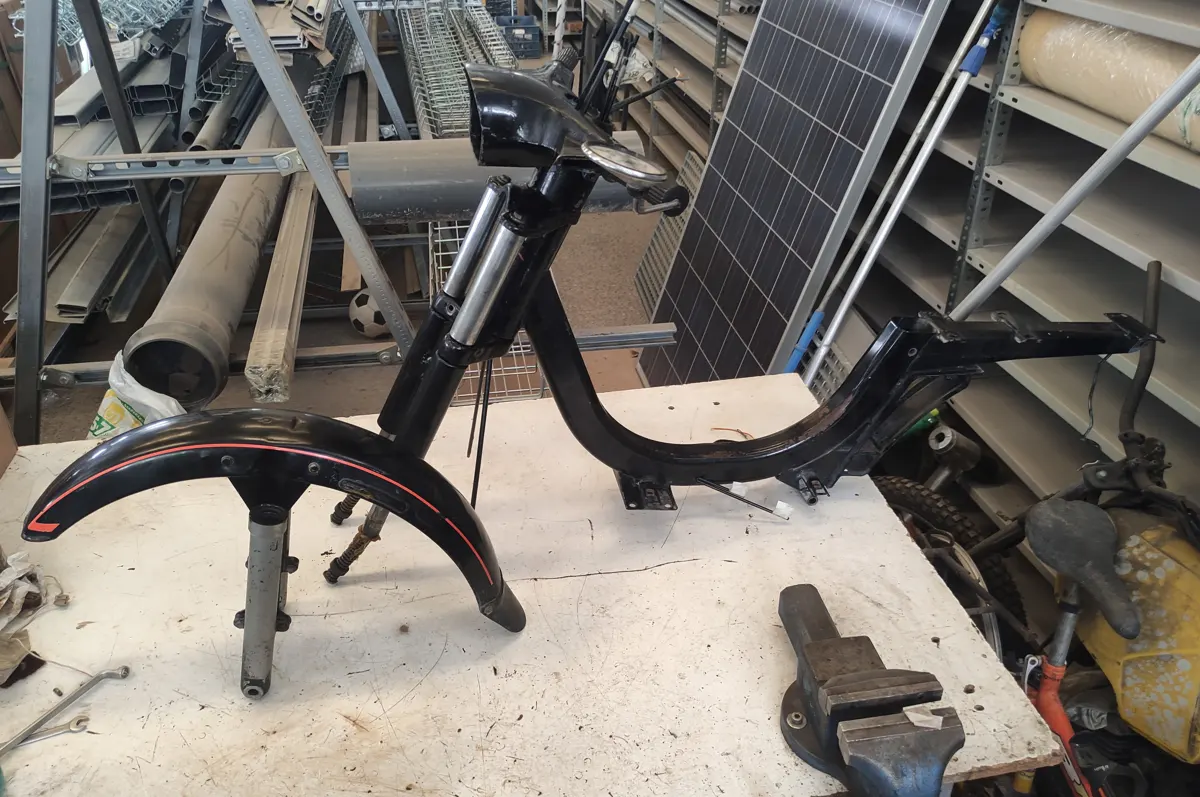 Chasis de vespino en proceso de montaje junto a suspensión delantera para montar