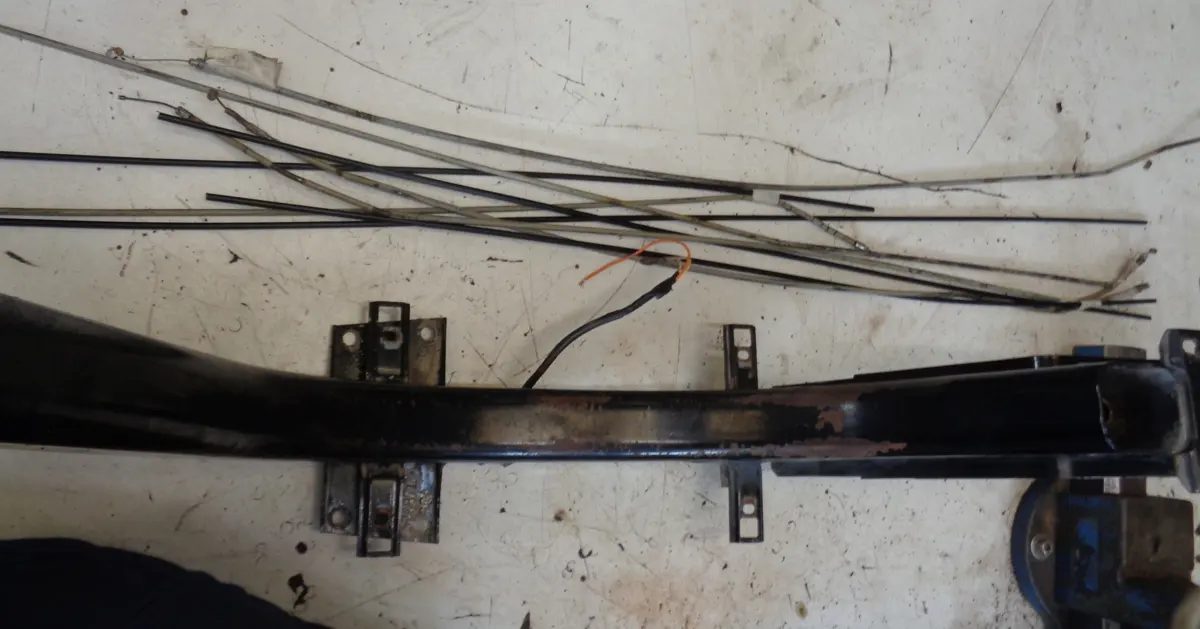Chasis de Vespino totalmente desmontado sobre una mesa con los cables mecánicos que se sustituiran junto a él para ser montados de nuevo