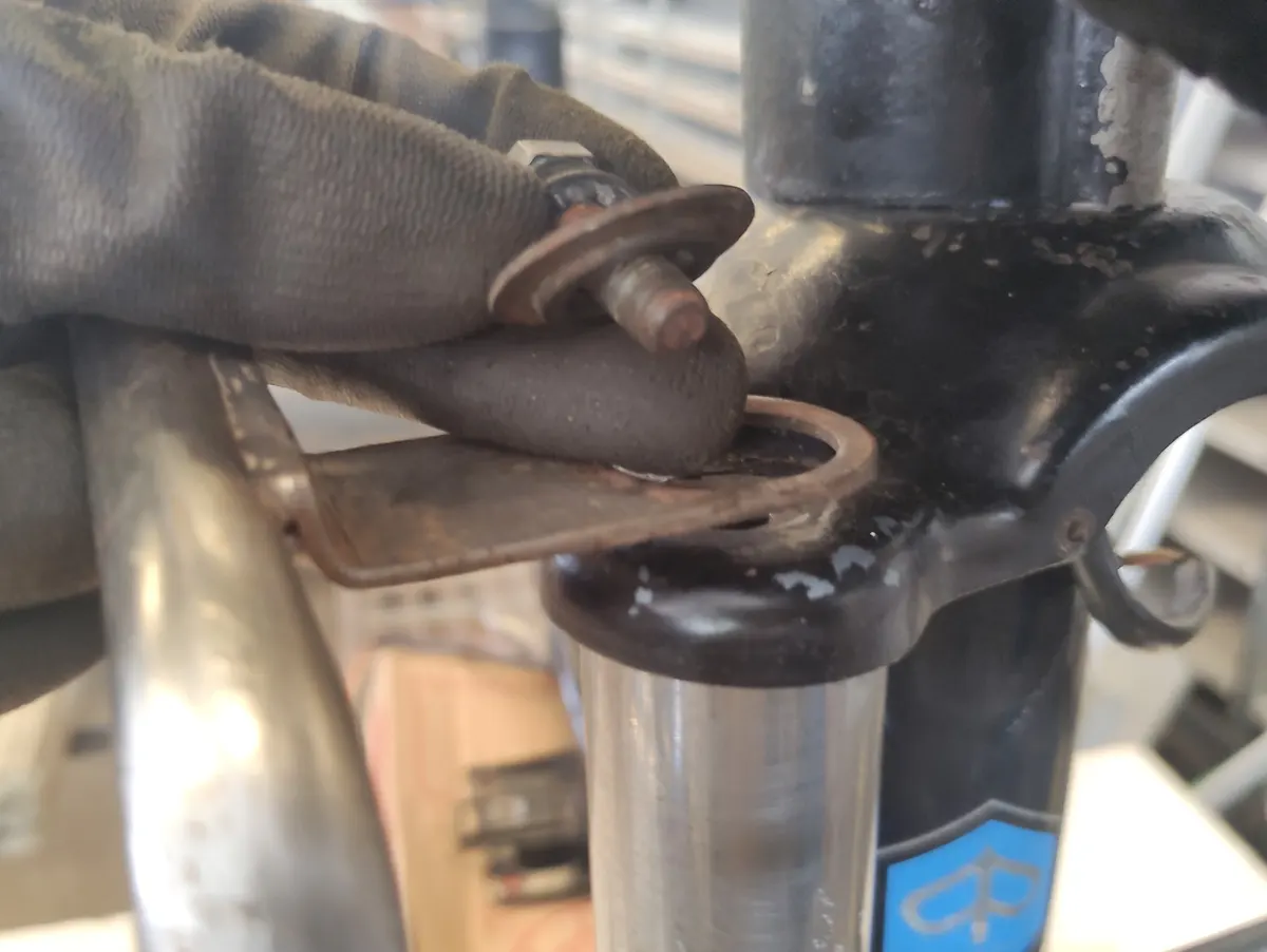 Tornillo superior de suspensión de Vespino con su arandela de portabultos frontal previo a ser montado