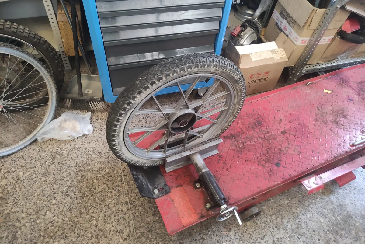 Rueda de vespino mordida en elevador de motos
